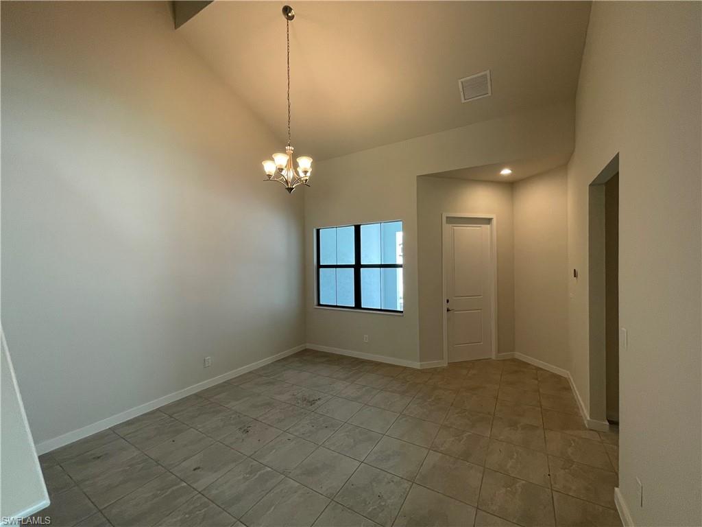 14815 Loggerhead Drive Naples, FL 34120 - Photo 10 of 29 an empty room with chandelier fan and windows