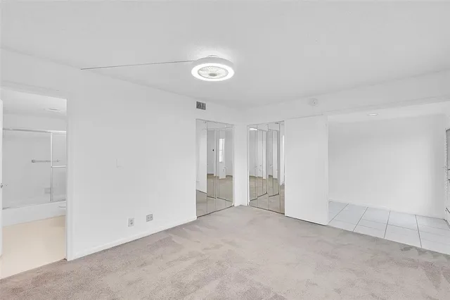 an empty room with windows and closet