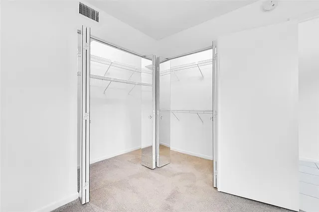 a view of a kitchen with white cabinets appliances and a window