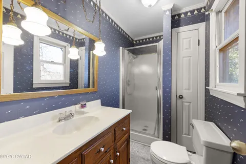 a bathroom with a sink vanity mirror and toilet