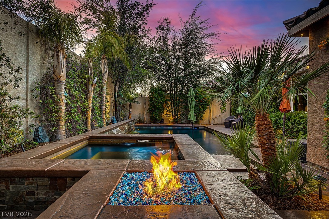 7415 Campbell Ranch Avenue Las Vegas, NV 89179 - Photo 2 of 52 An inviting backyard oasis offers a sparkling pool and spa with a captivating fire pit, perfect for evening relaxation.