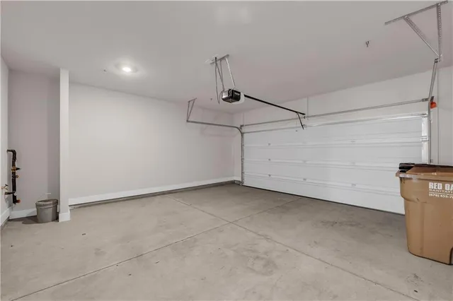 a large white kitchen with kitchen island a sink white cabinets and stainless steel appliances