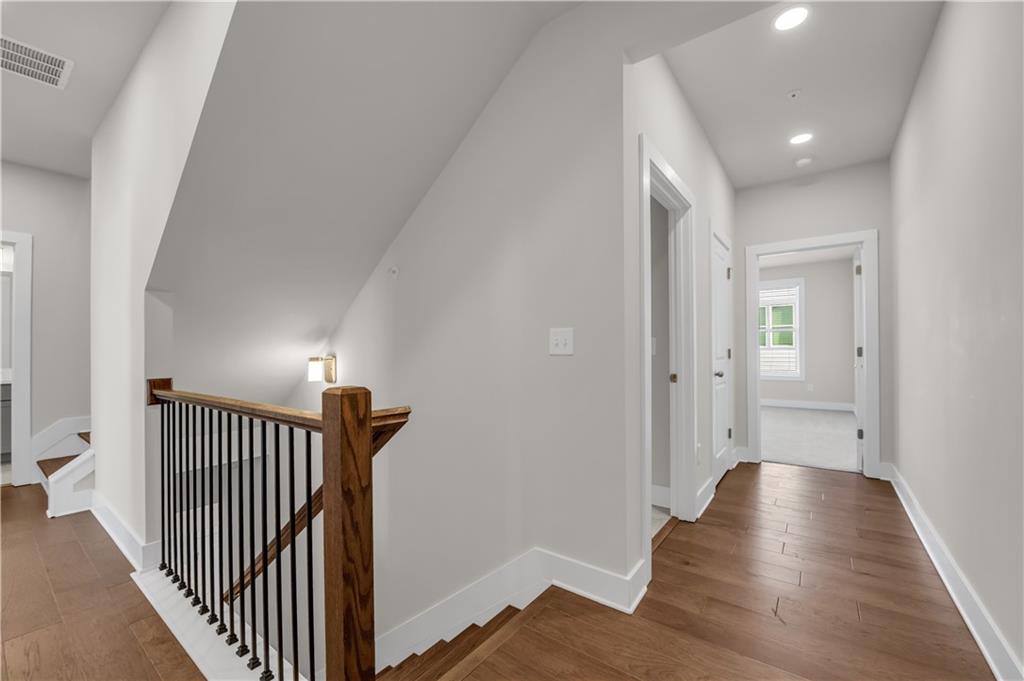 1230 Weatherway Lane Cumming, GA 30041 - Photo 13 of 34 a view of a hallway with wooden floor and a bathroom