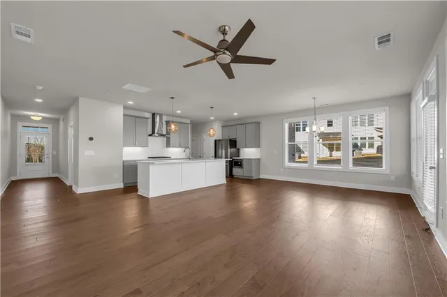 a view of an empty room and kitchen view