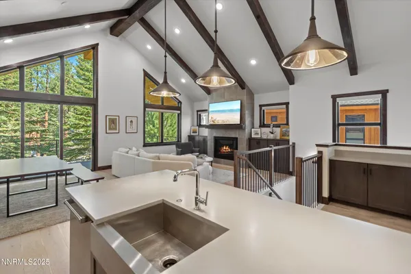 a living room with furniture a large window a table and chairs