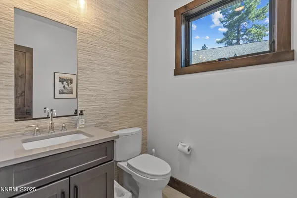 a bathroom with a toilet a sink and mirror