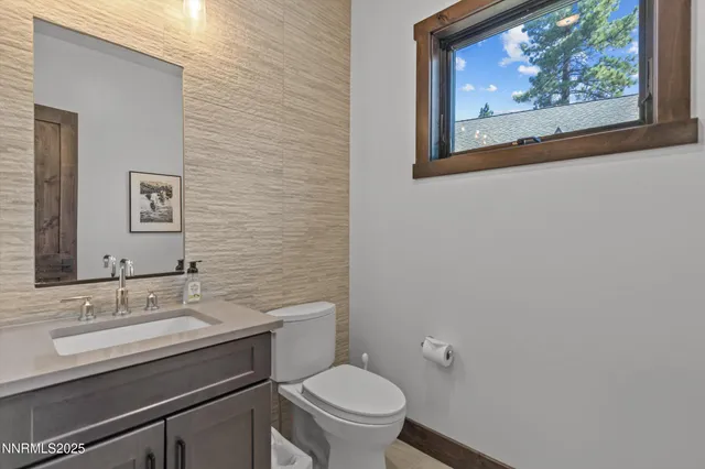 a bathroom with a toilet a sink and mirror