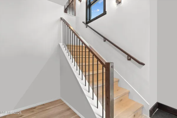 a view of staircase with wooden floor and white walls