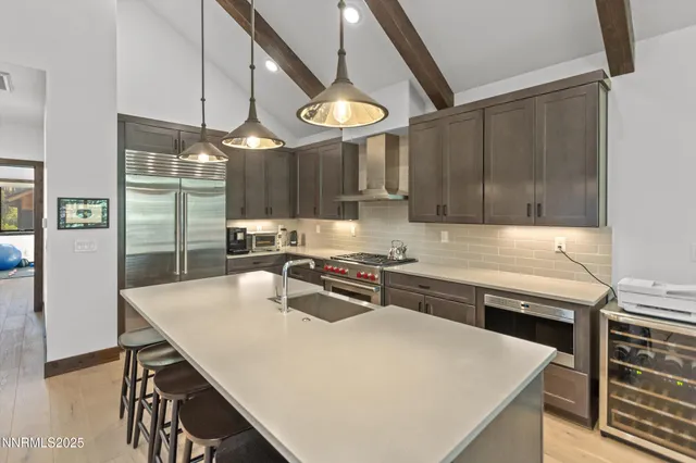 a kitchen with stainless steel appliances granite countertop a sink a stove and a refrigerator