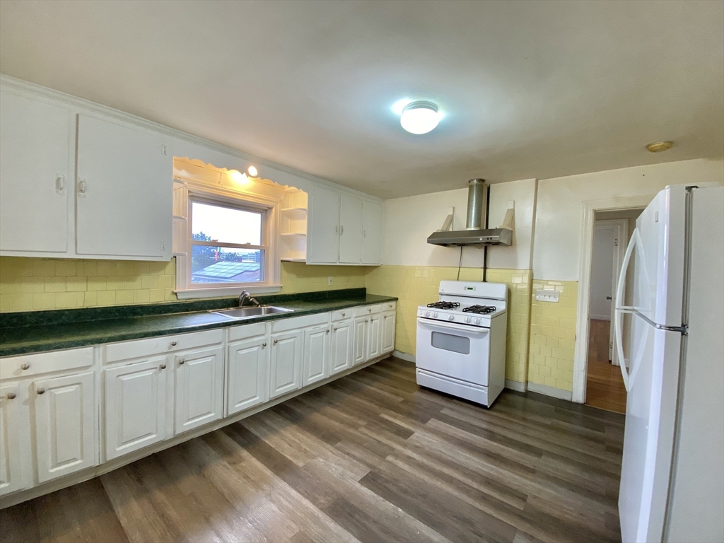 a kitchen with stainless steel appliances a stove a sink and white cabinets