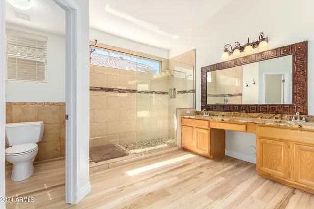 a bathroom with a granite countertop sink mirror vanity and bathtub