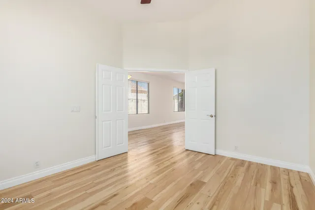 an empty room with wooden floor and windows