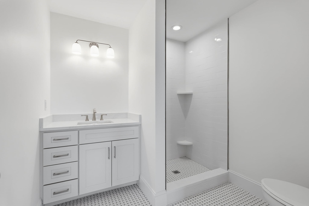16 Couture Way Middleton, MA 01949 - Photo 32 of 36 a bathroom with a granite countertop sink a mirror and a bathtub