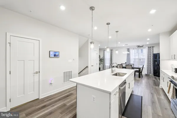 a kitchen with a refrigerator a sink and a stove top oven