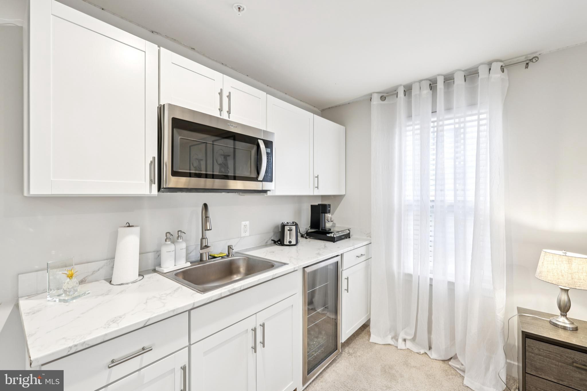 1716 Atlas Drive Frederick, MD 21702 - Photo 20 of 48 a kitchen with stainless steel appliances a sink a stove a microwave cabinets and a window