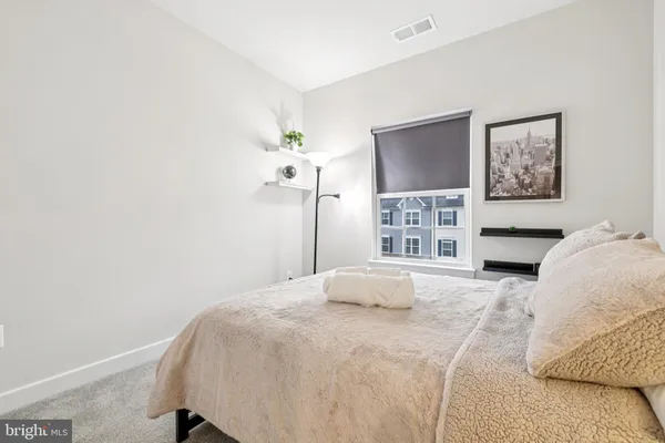 a bedroom with a bed and a painting on the wall