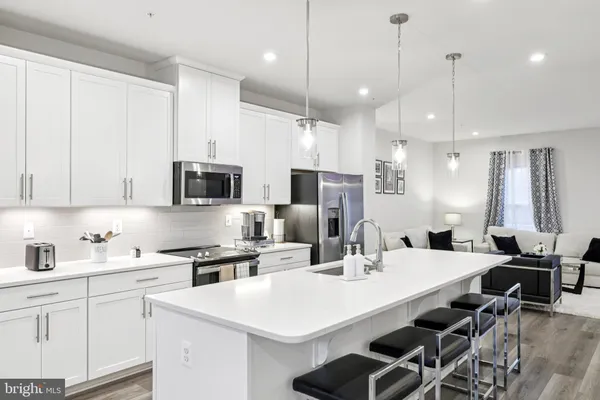 a kitchen with stainless steel appliances kitchen island a white table and chairs