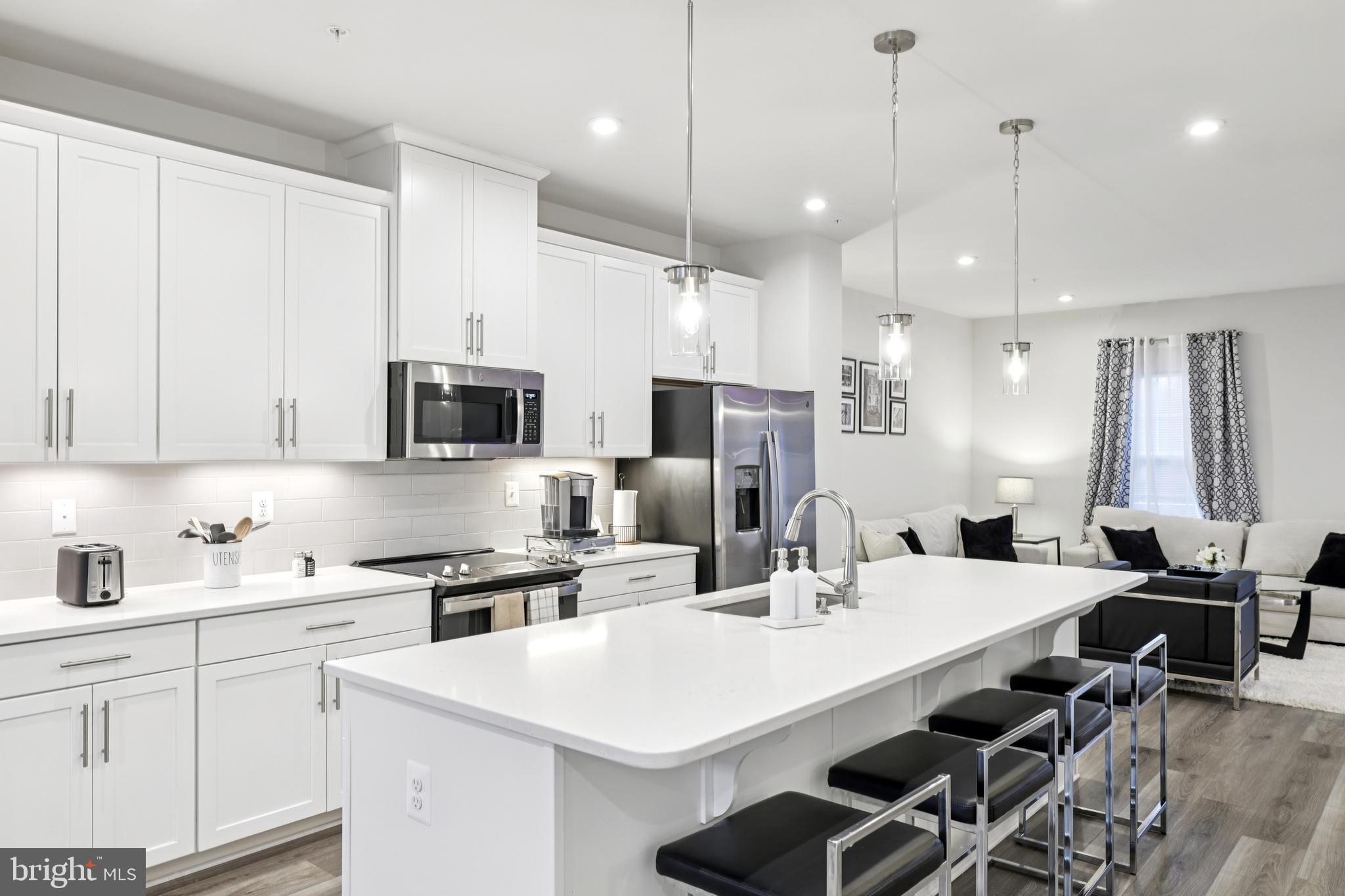 1716 Atlas Drive Frederick, MD 21702 - Photo 8 of 48 a kitchen with stainless steel appliances kitchen island a white table and chairs
