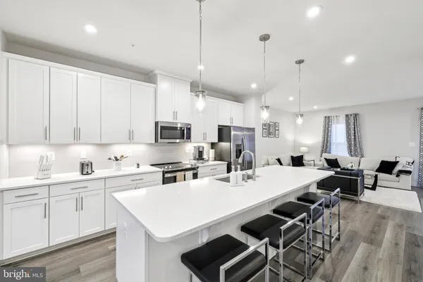 a large kitchen with kitchen island a sink table and chairs
