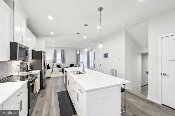 a kitchen with a sink a counter top space stainless steel appliances and cabinets