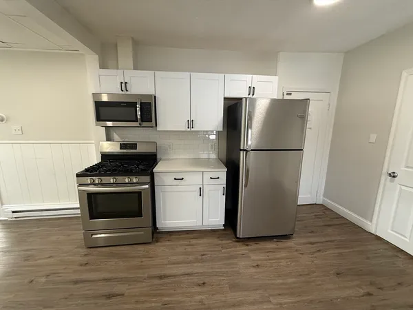 a kitchen with stainless steel appliances a refrigerator stove and microwave