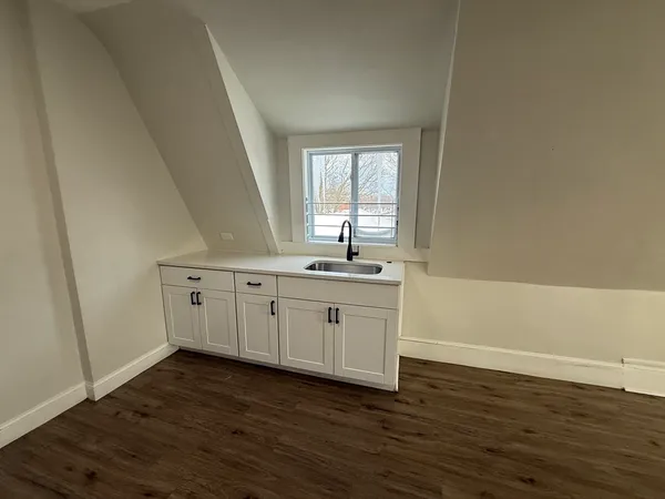 a view of a kitchen with sink cabinets and wooden floor