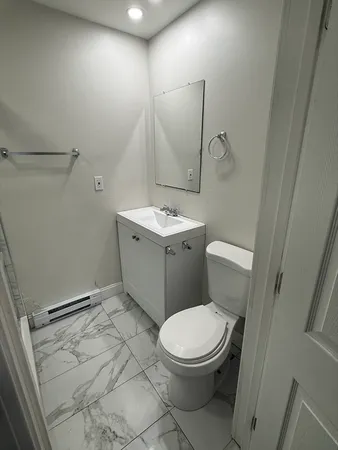 a bathroom with a toilet sink and mirror