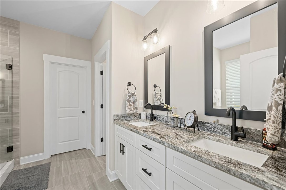 6834 Midway Road Pelzer, SC 29669 - Photo 27 of 50 This serene bathroom offers a spacious double vanity with ample storage and sleek fixtures.