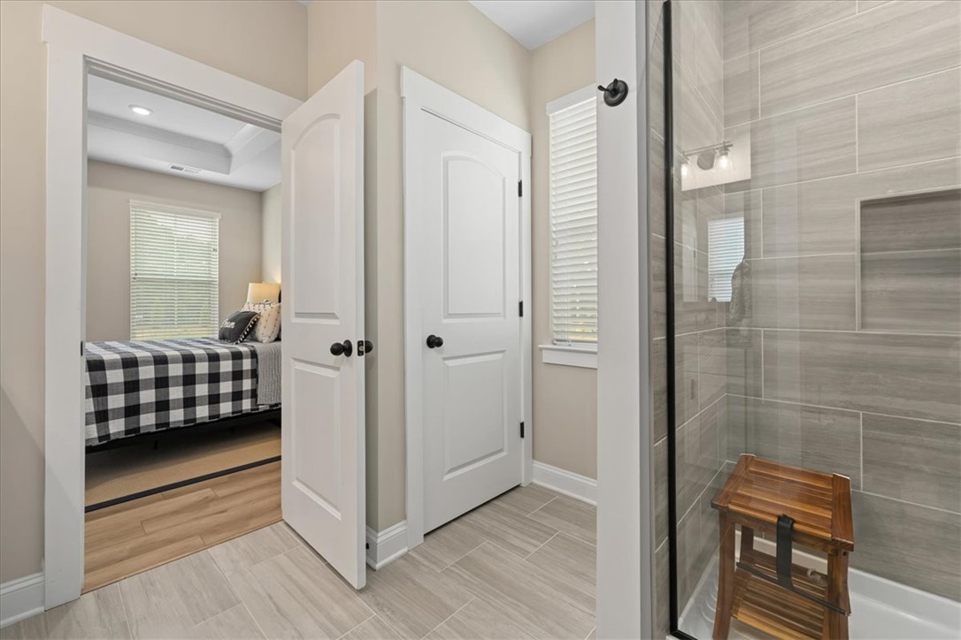 6834 Midway Road Pelzer, SC 29669 - Photo 30 of 50 This bright bathroom features a spacious shower and direct access to a cozy bedroom.