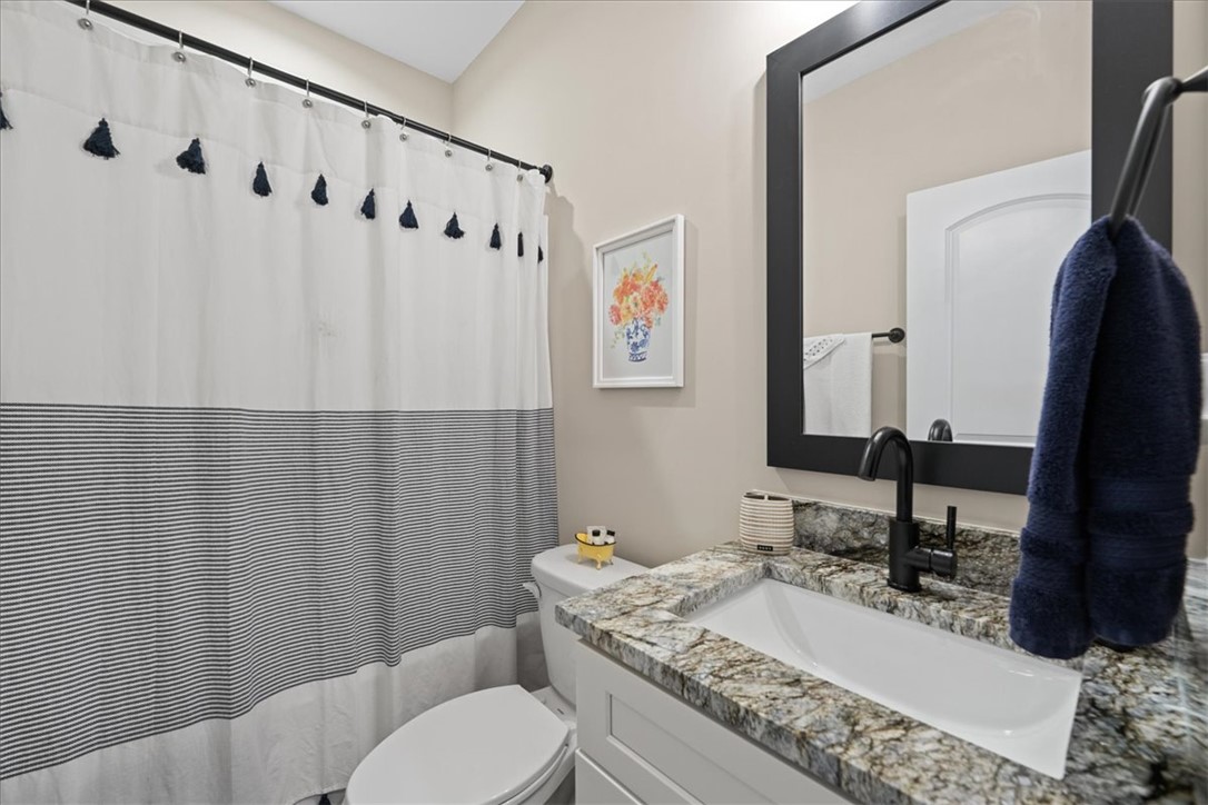 6834 Midway Road Pelzer, SC 29669 - Photo 32 of 50 This bathroom features a contemporary vanity with a granite counter and a framed mirror.