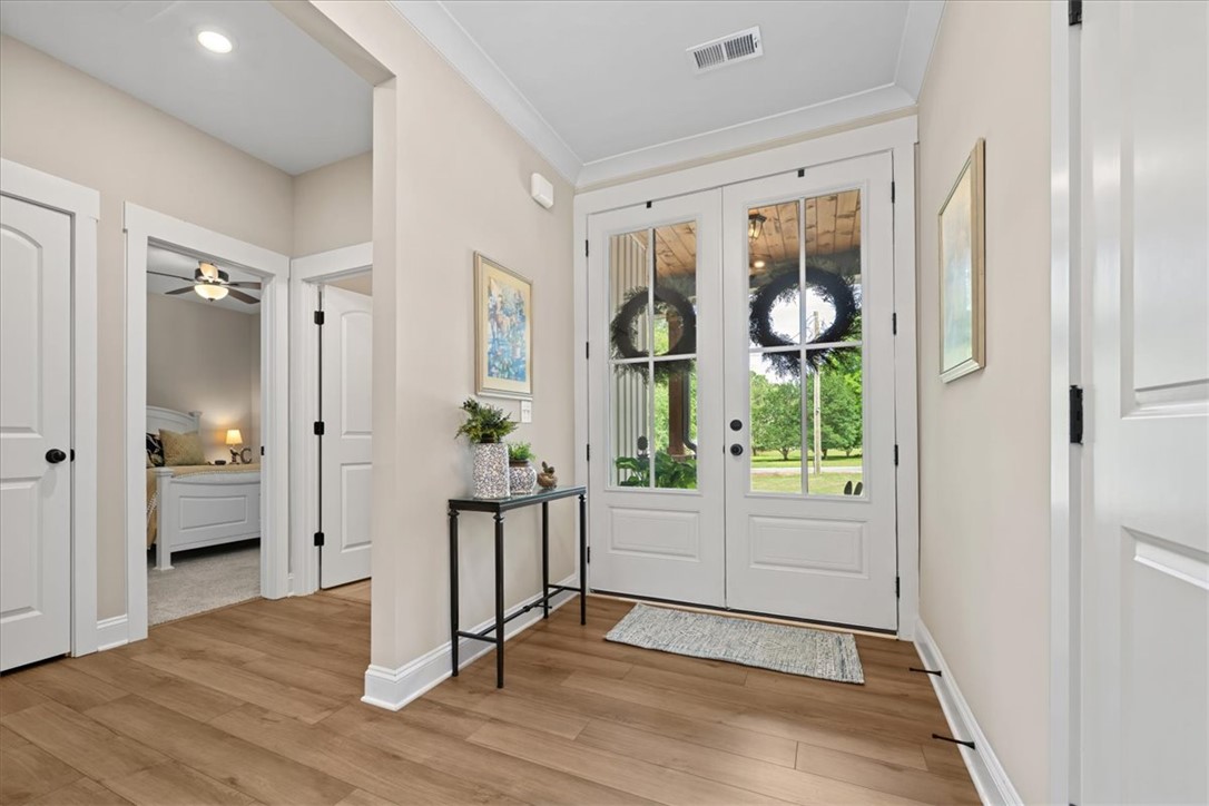 6834 Midway Road Pelzer, SC 29669 - Photo 4 of 50 Enter into a bright and inviting hallway featuring beautiful wood flooring and elegant French doors.