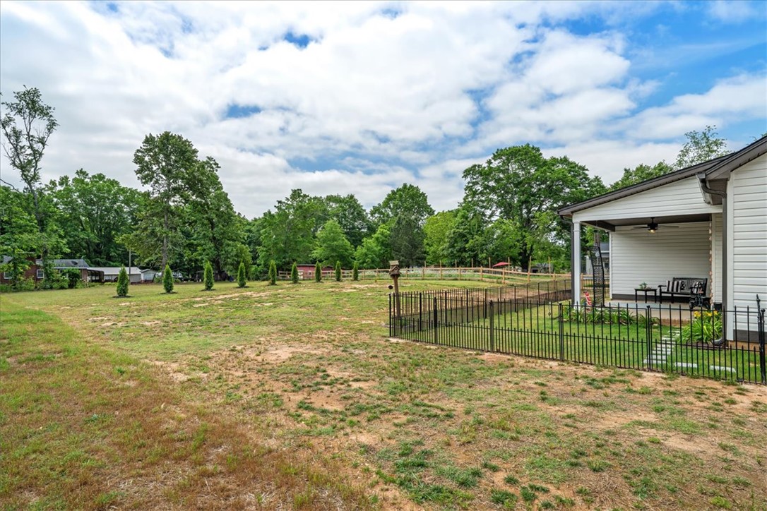 6834 Midway Road Pelzer, SC 29669 - Photo 44 of 50 This spacious yard features a charming covered porch and durable fencing, perfect for outdoor enjoyment.