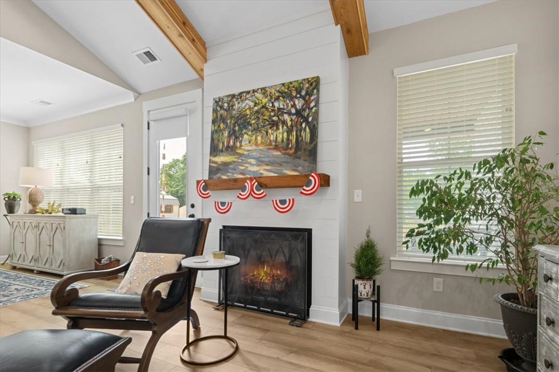 6834 Midway Road Pelzer, SC 29669 - Photo 49 of 50 This inviting living space features warm wood flooring and a cozy fireplace, perfect for relaxation.