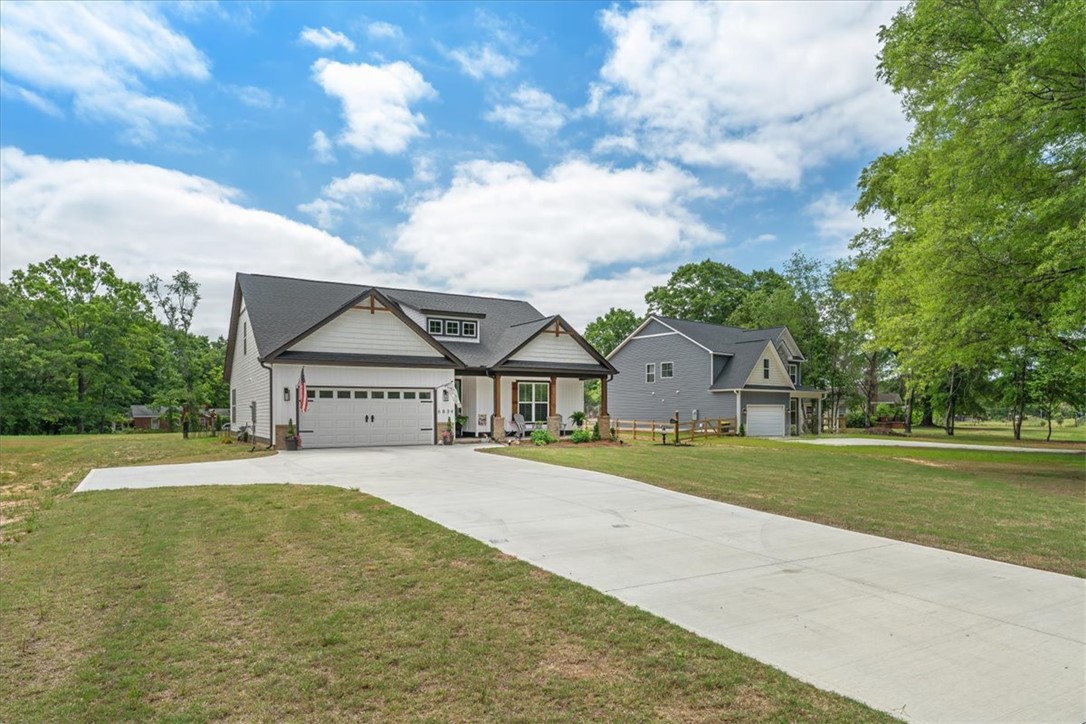 6834 Midway Road Pelzer, SC 29669 - Photo 50 of 50 This charming home offers a spacious driveway, welcoming porch, and ample garage space.