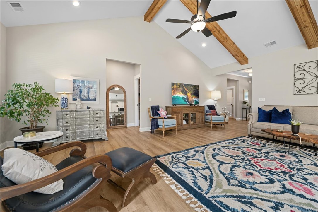 6834 Midway Road Pelzer, SC 29669 - Photo 7 of 50 This airy living room features high vaulted ceilings with exposed wood beams, creating an inviting atmosphere.