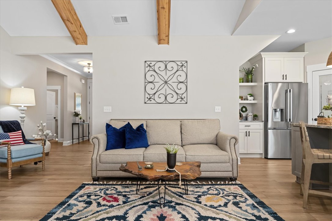 6834 Midway Road Pelzer, SC 29669 - Photo 8 of 50 This inviting living space features warm wood beams and seamless kitchen access for modern living.