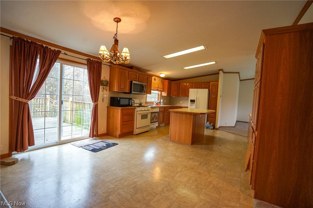 37632 Sheepskin Ridge Road Lower Salem, OH 45745 - Photo 3 of 30 Kitchen with decorative light fixtures, light tile floors, white appliances, vaulted ceiling, and a notable chandelier