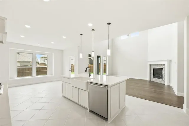 a large white kitchen with sink and washing machine