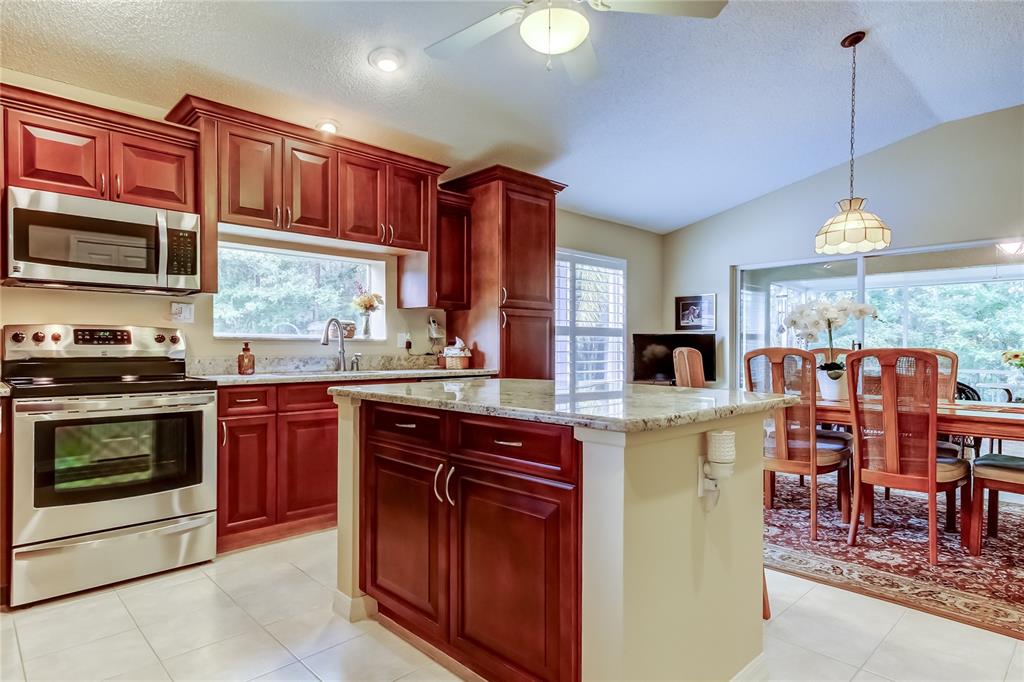 1610 Cortleigh Drive Trinity, FL 34655 - Photo 13 of 72 a kitchen with stainless steel appliances granite countertop a stove top oven a sink dishwasher and a microwave oven on the blue kitchen countertops