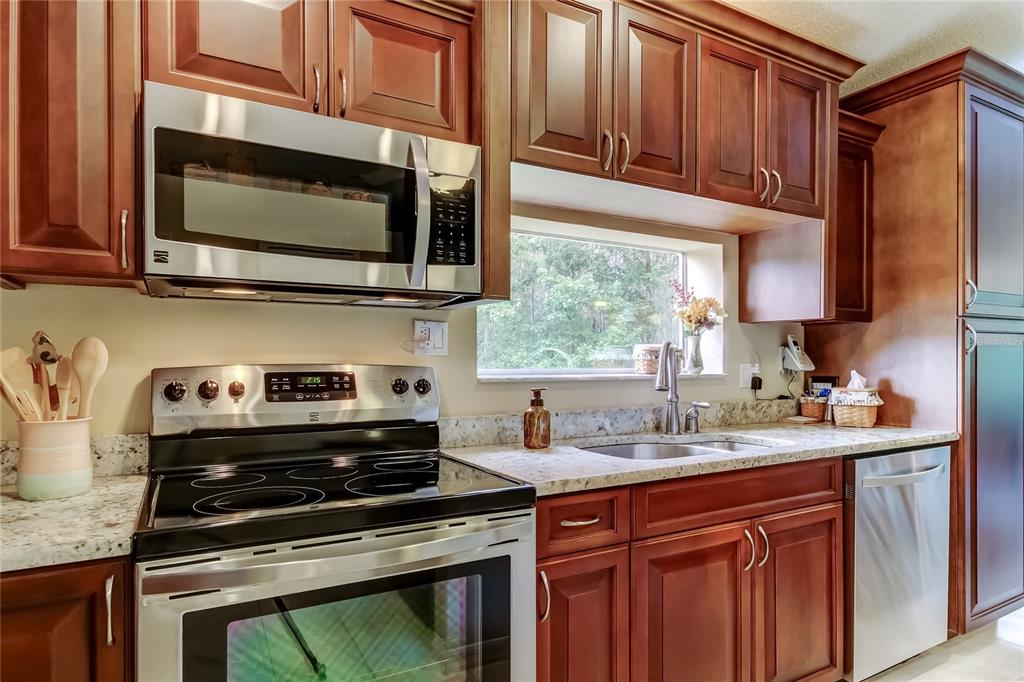 1610 Cortleigh Drive Trinity, FL 34655 - Photo 19 of 72 a kitchen with stainless steel appliances a stove a sink a microwave and cabinets