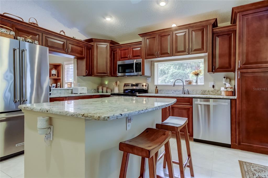 1610 Cortleigh Drive Trinity, FL 34655 - Photo 22 of 72 a kitchen with stainless steel appliances granite countertop a stove a sink and a refrigerator