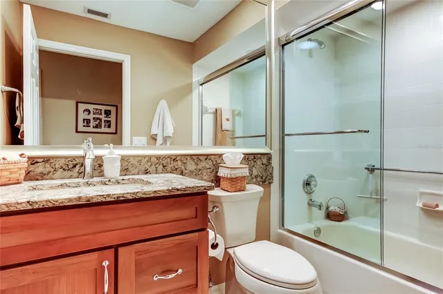 a bathroom with a granite countertop sink mirror and shower