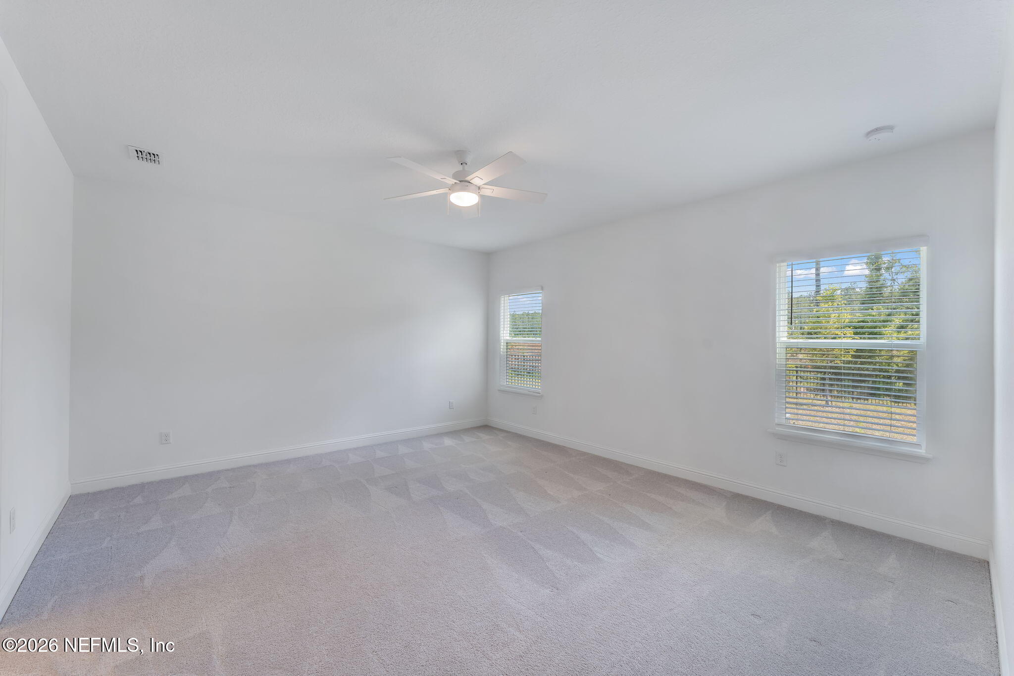 75776 Estuary Way Yulee, FL 32097 - Photo 11 of 20 an empty room with chandelier fan and windows