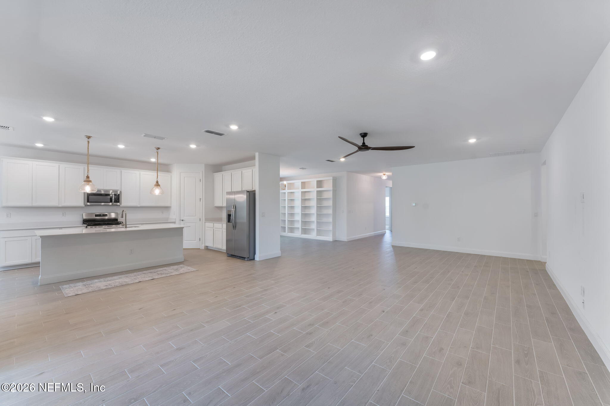75776 Estuary Way Yulee, FL 32097 - Photo 3 of 20 a view of kitchen with kitchen island a sink wooden floor and a refrigerator