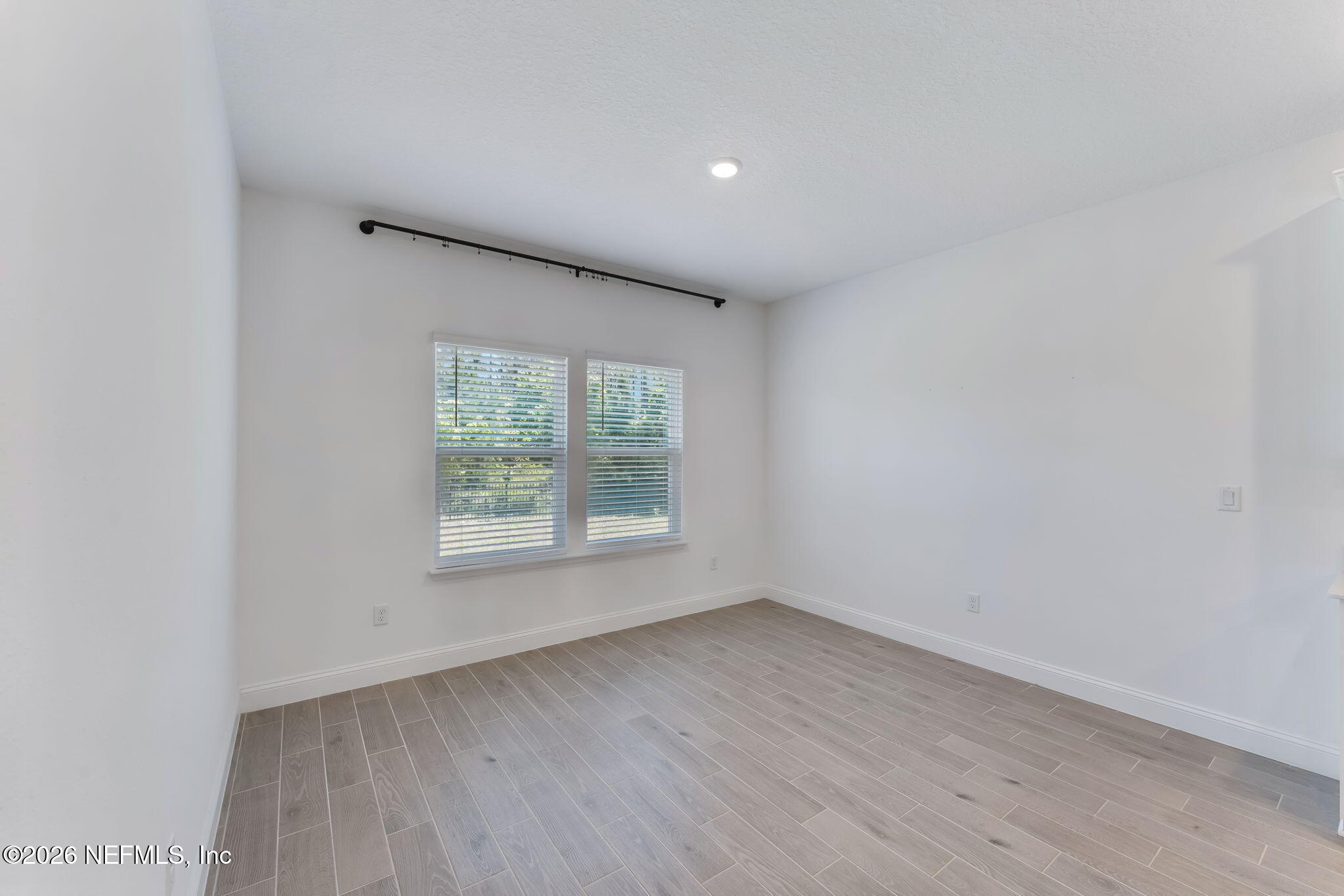 75776 Estuary Way Yulee, FL 32097 - Photo 7 of 20 an empty room with wooden floor and window