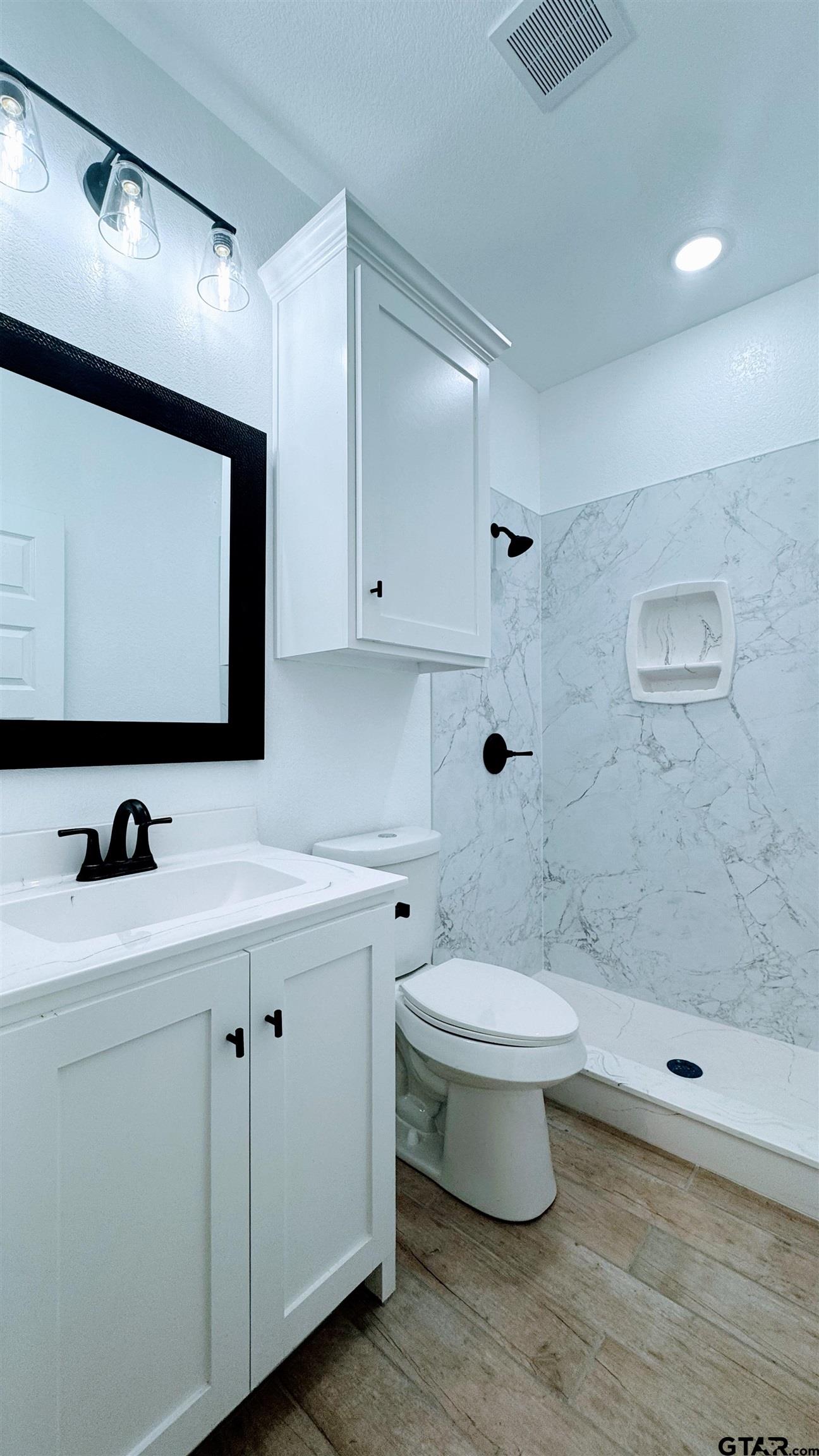 20428 High Point Drive Flint, TX 75762 - Photo 11 of 18 a bathroom with a toilet sink and mirror