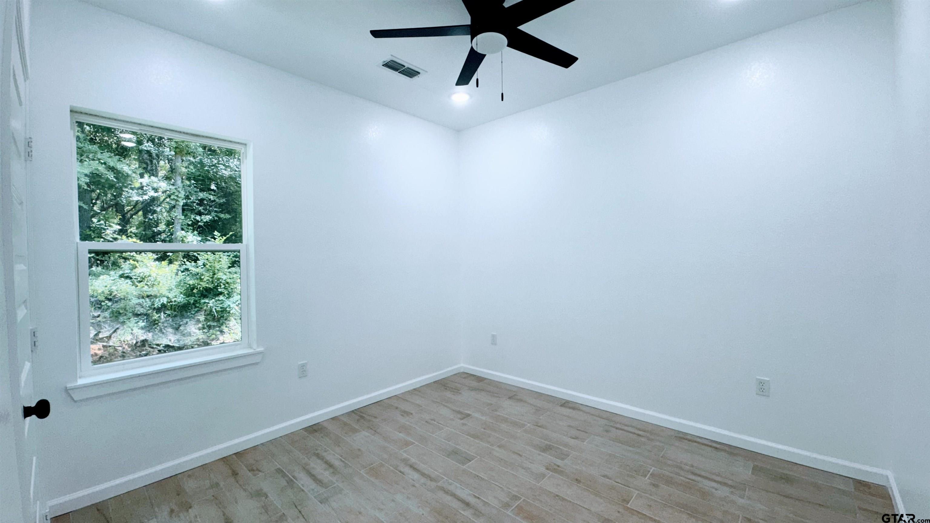 20428 High Point Drive Flint, TX 75762 - Photo 12 of 18 a view of empty room with wooden floor and fan