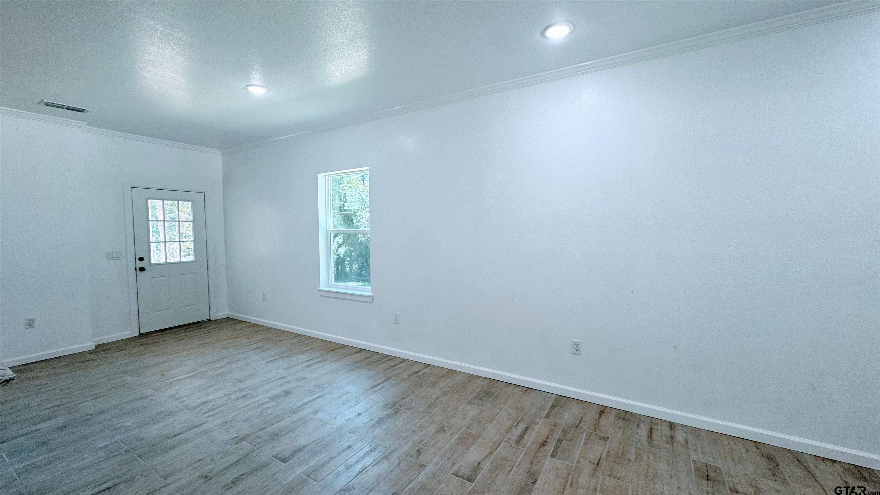 20428 High Point Drive Flint, TX 75762 - Photo 13 of 18 an empty room with wooden floor and windows