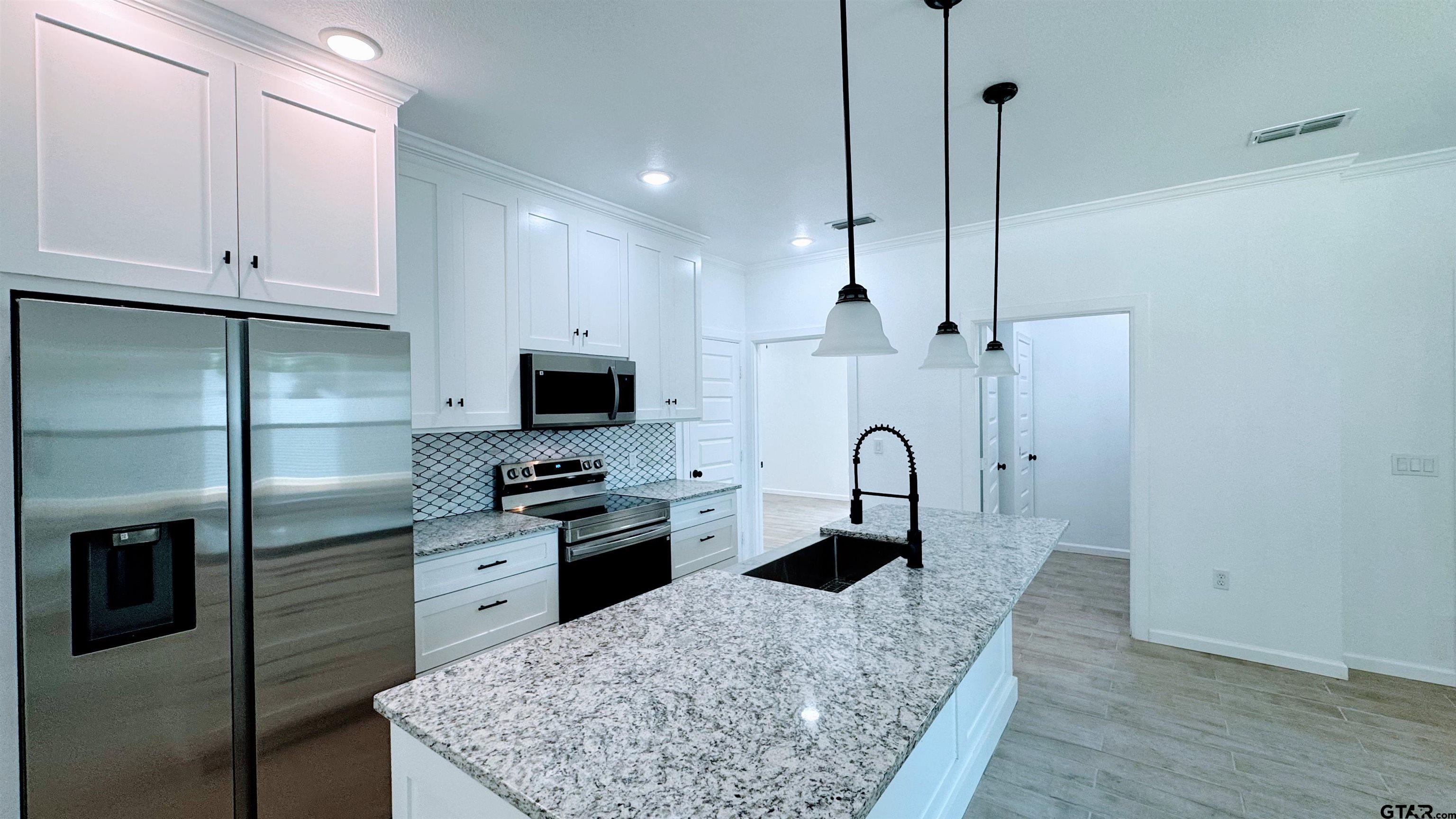 20428 High Point Drive Flint, TX 75762 - Photo 5 of 18 a kitchen with stainless steel appliances granite countertop a sink a stove and a refrigerator