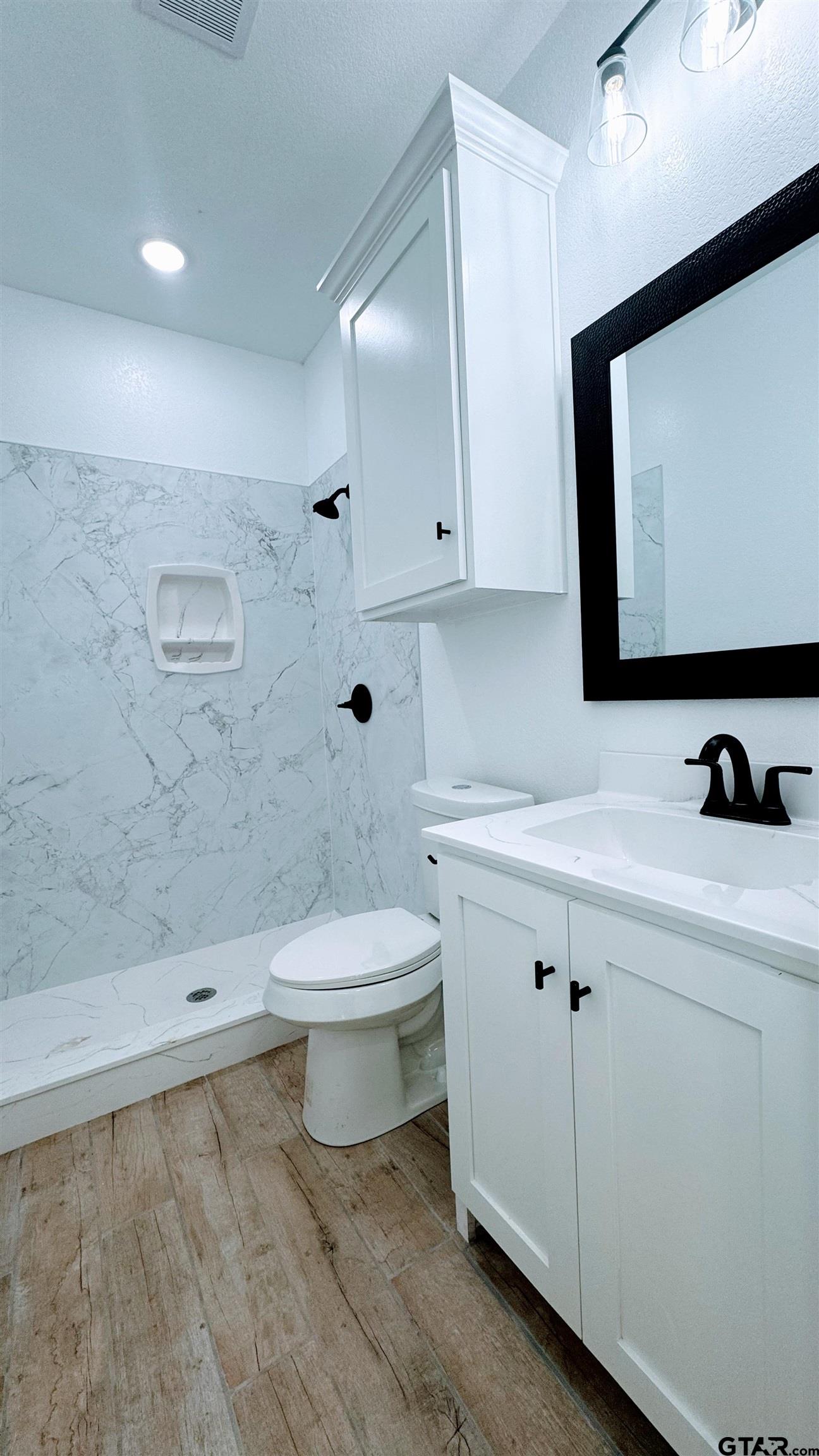 20428 High Point Drive Flint, TX 75762 - Photo 9 of 18 a bathroom with a sink a toilet and a mirror